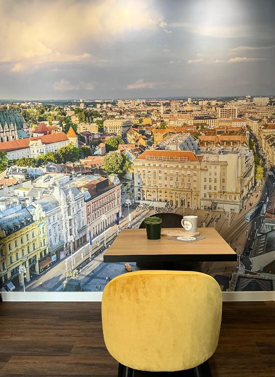 a table and two yellow chairs in front of a window at B&B View in Zagreb