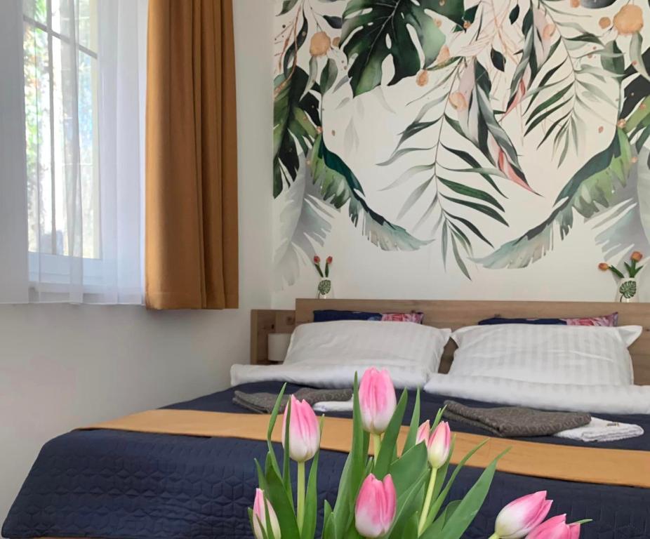1 dormitorio con 2 camas con tulipanes rosas en Sóvirág Apartman en Egerszalók