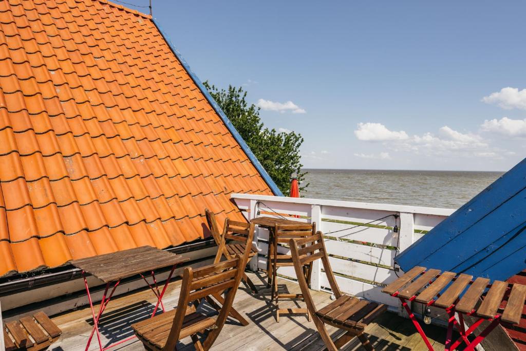 two chairs and a table on the deck of a boat at Guboja in Nida