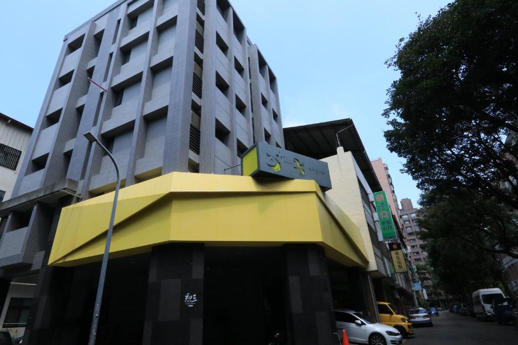 a building with a yellow awning in front of it at 逢甲25行館Fengjia 25 Hotel in Taichung