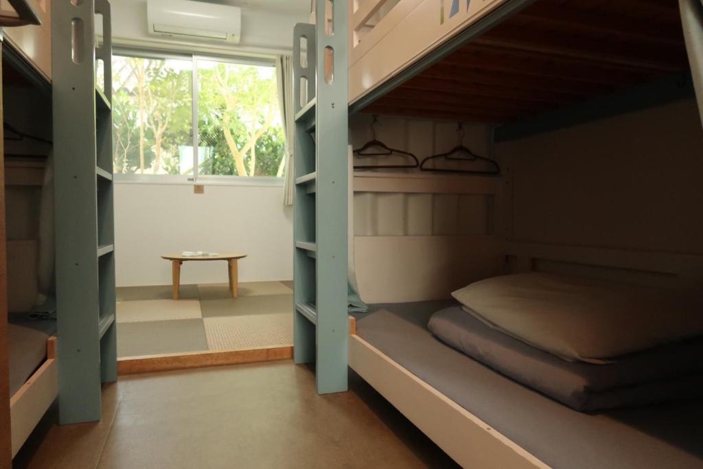 a room with two bunk beds and a window at HOSTEL SunTerrace Ishigaki in Ishigaki Island
