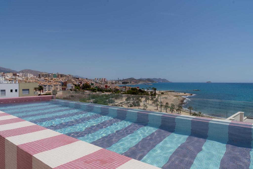 a large swimming pool with a view of the ocean at NIU Line - Be Line Group in Villajoyosa