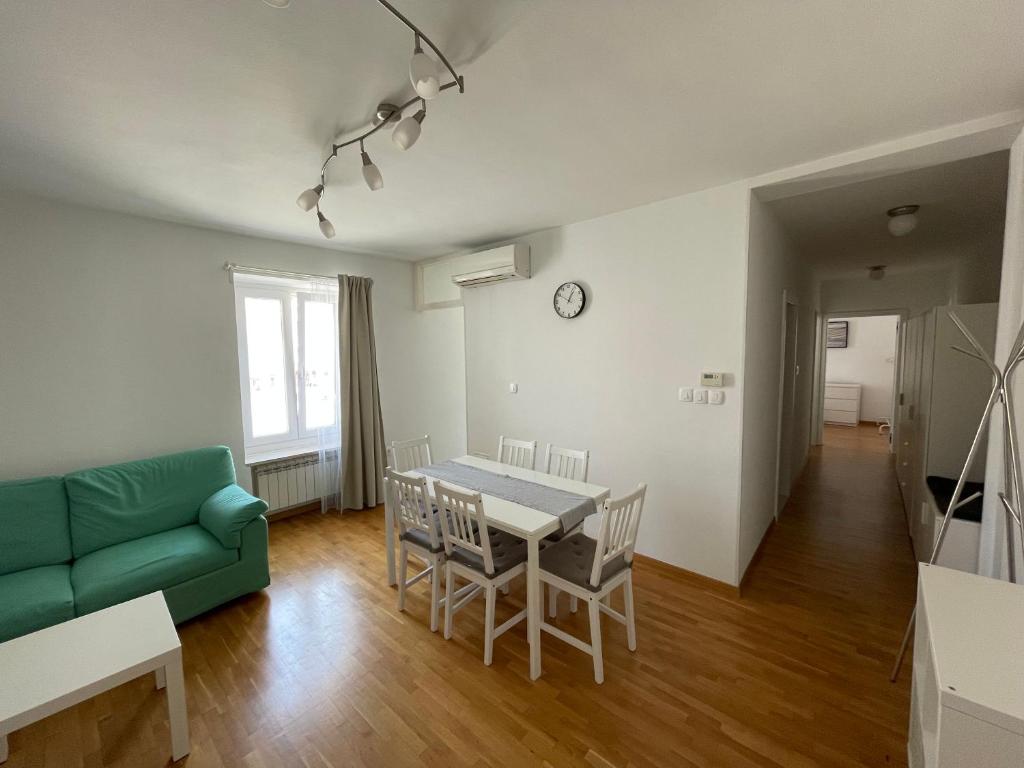 a living room with a table and a green couch at Apartment Tartini in Piran