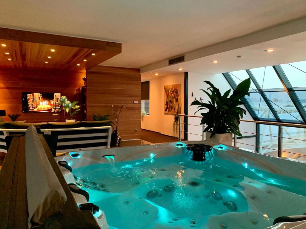 a hot tub in a room with a large window at Wellness Dome Penthouse in Kerkrade