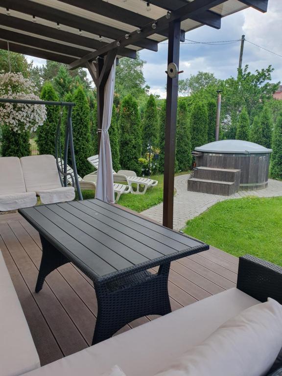 a wooden deck with a picnic table and a gazebo at Лора in Lapmežciems