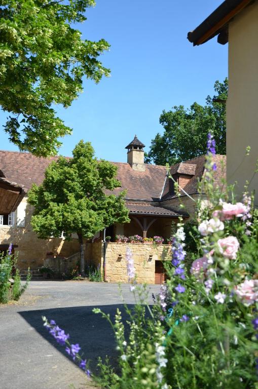 un bâtiment avec un bouquet de fleurs devant dans l'établissement Chambre Périgourdine, à Beynac-et-Cazenac