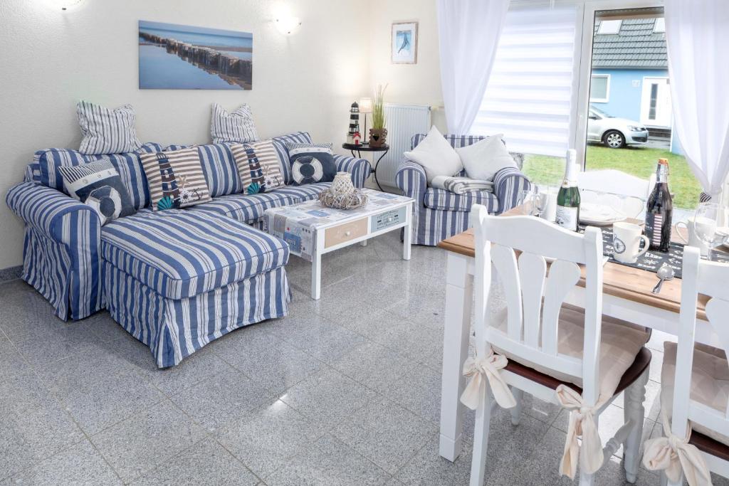 a living room with blue and white couches and a table at Ferienhaus Kranich in Pruchten