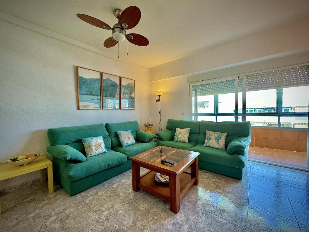 ein Wohnzimmer mit einer grünen Couch und einem Tisch in der Unterkunft Marbella Central 5 by Homing in Marbella