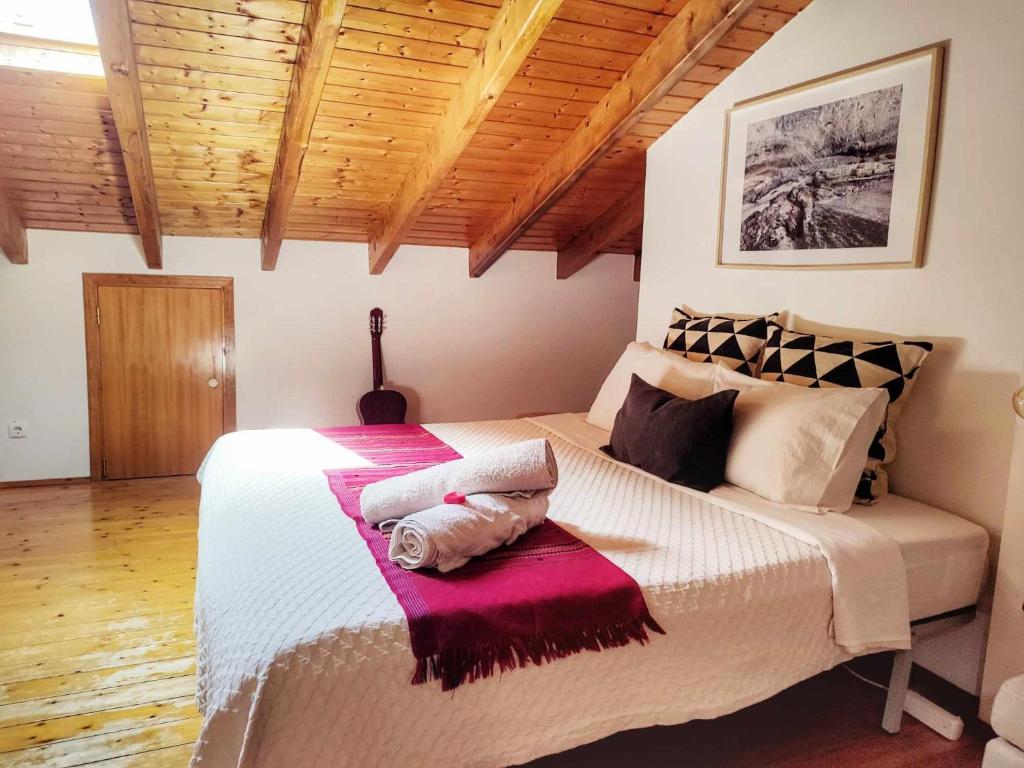 a bedroom with a large bed in a room with wooden ceilings at Homestay Attic Private Bedroom in Aljezur