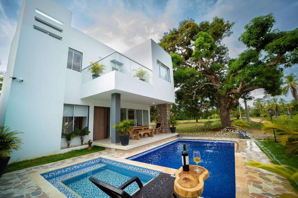 une villa avec piscine et une maison dans l'établissement Cabaña Villa July, à Moñitos