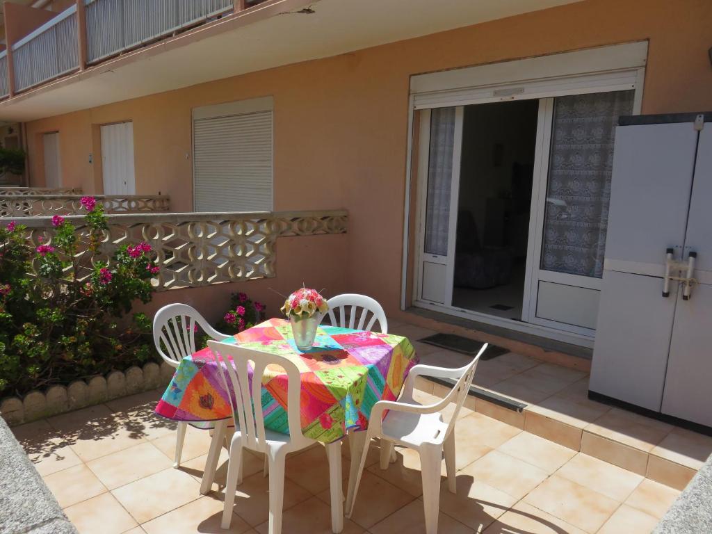 une table et des chaises sur le patio d'une maison dans l'établissement Le Géranium, à Port-la-Nouvelle