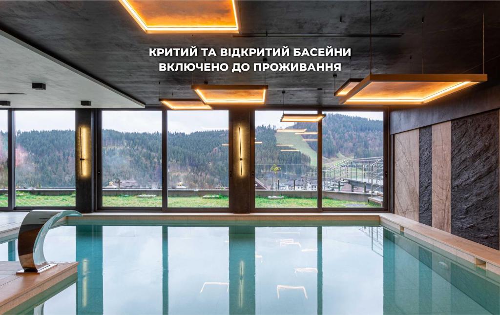 a swimming pool in a building with a view of a mountain at Didukh Eco Hotel&Spa in Bukovel