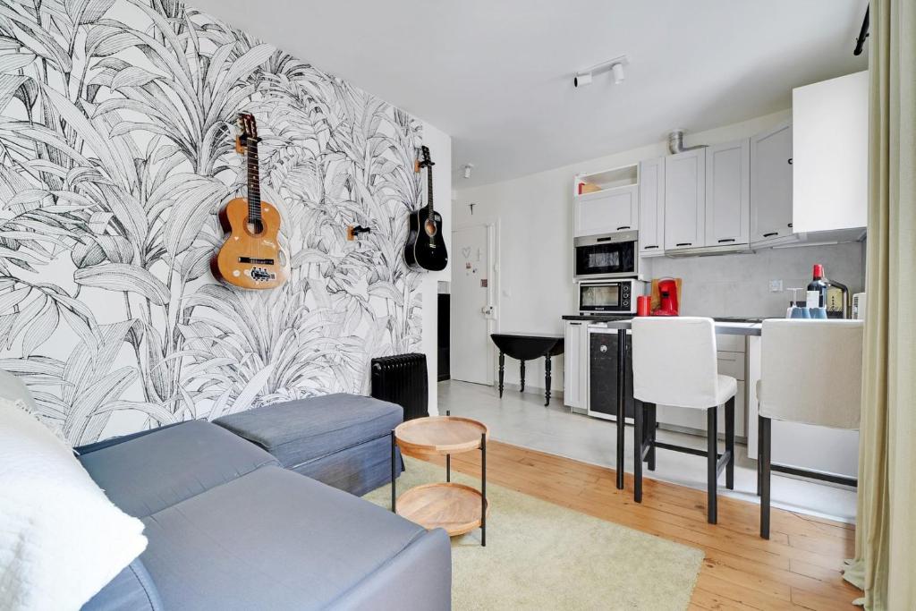 - un salon avec une guitare sur un mur dans l'établissement GuestReady - Modern Comfort near Montparnasse, à Paris