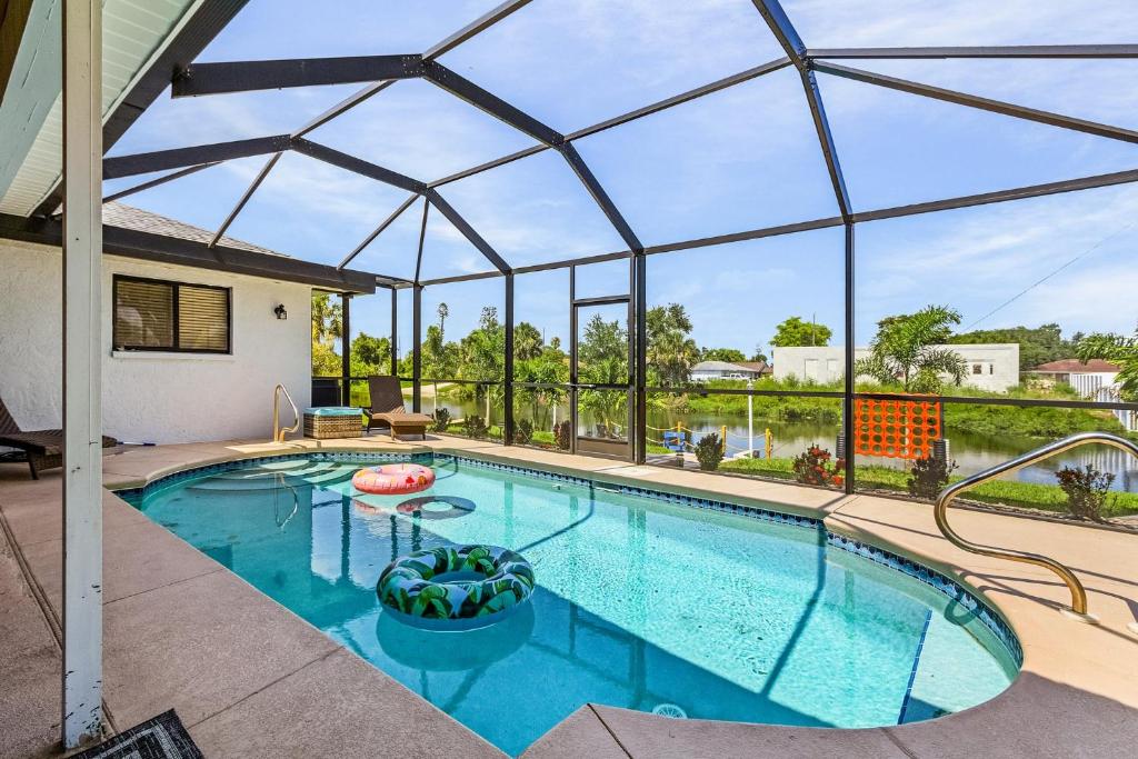 a swimming pool with a large glass roof at Cozy Retreat, heated pool, water canal, bikes,3 bedroom in Cape Coral
