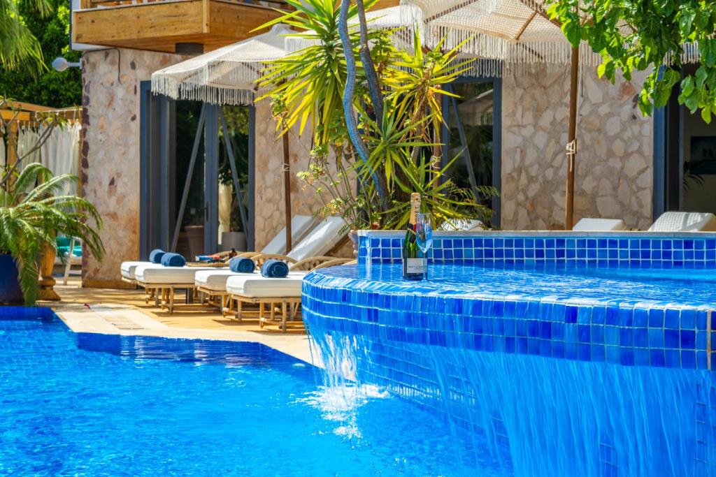 a swimming pool with blue tiles on the side at Elixir Hotel in Kalkan