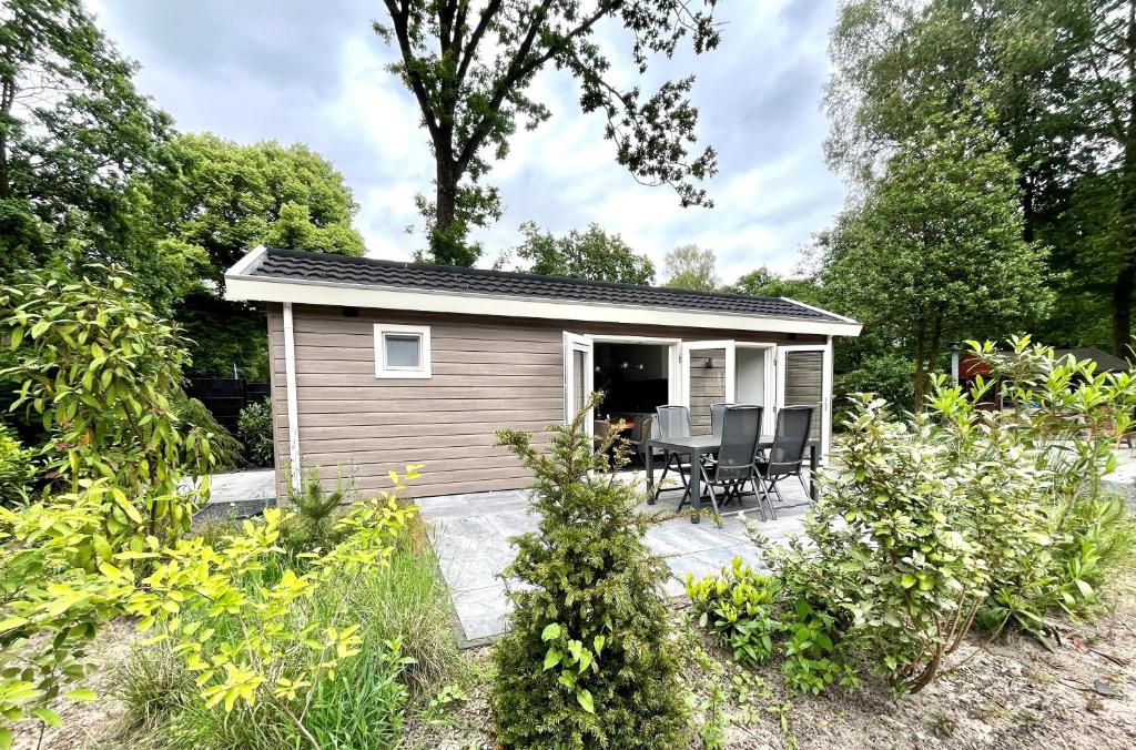 a small shed with a table and chairs in a garden at Camping de Vinkenkamp in Lieren