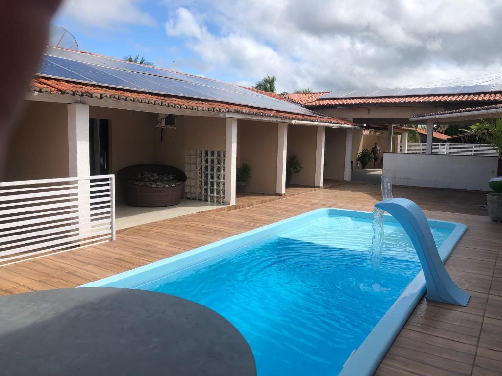 a swimming pool with a water slide in front of a house at Pousada Kactus in Piranhas