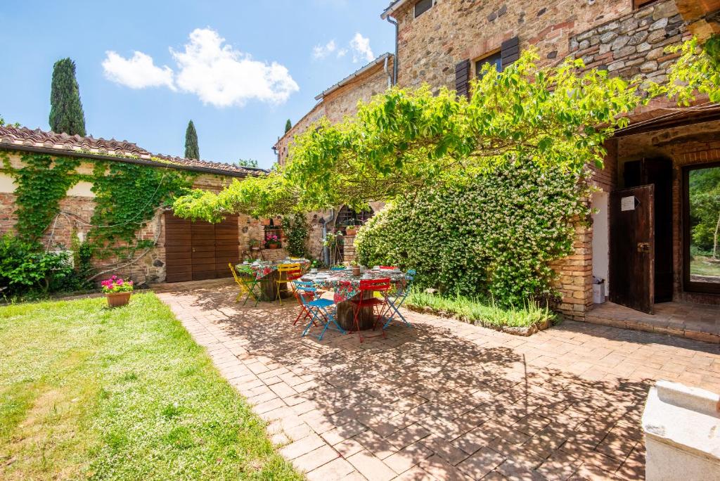 Un patio con una mesa y sillas en un patio. en Casa Alta Villa esclusiva, en Murlo