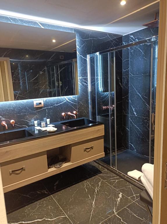 a bathroom with a sink and a glass shower at Miramare Suites in Sestri Levante