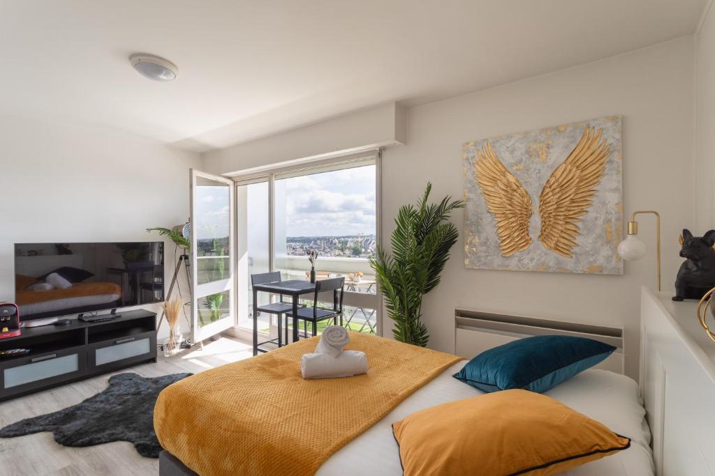 une chambre avec un lit et une grande fenêtre dans l'établissement Le Studio de l'Ange - Vue imprenable, à Rennes