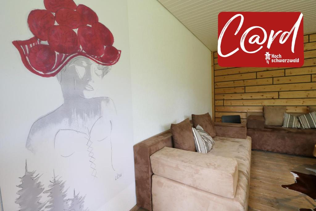 姆根布朗Fewo "am Mühlenbach" im Haus Hohfels, 2 Schlafzimmer, Todtnau-Muggenbrunn, Hochschwarzwald的一间配有沙发的房间和墙上的标志