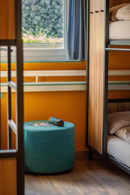 a room with a green ottoman in a room with bunk beds at Eiger Lodge Easy in Grindelwald
