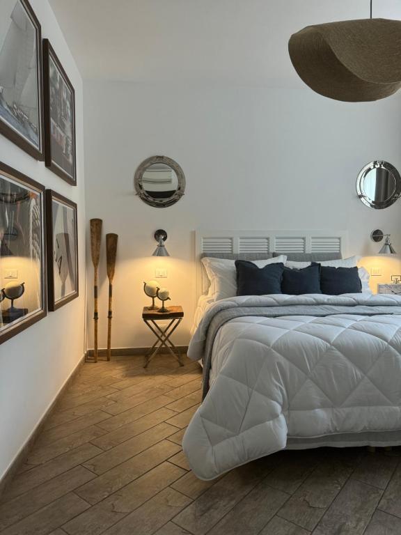 a white bedroom with a bed and a wooden floor at Villa Marina in Marina dʼAndora