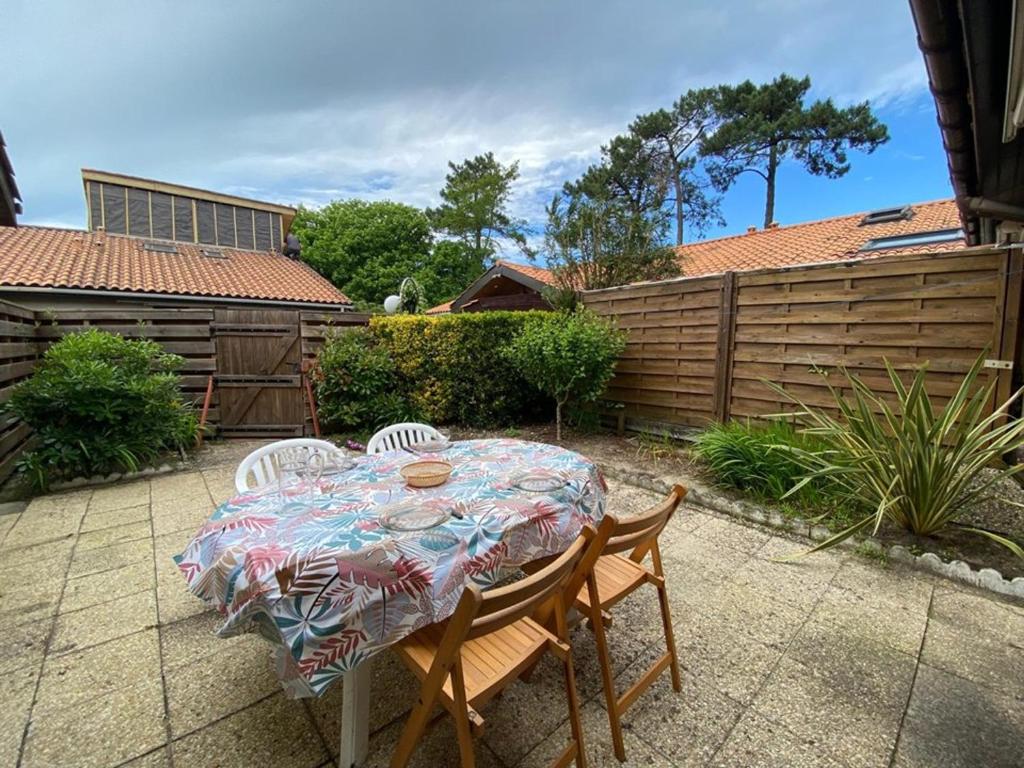 une table et des chaises dans une arrière-cour avec une clôture dans l'établissement Villa rénovée avec grande terrasse, 5 pers, Capbreton - FR-1-413-164, à Capbreton