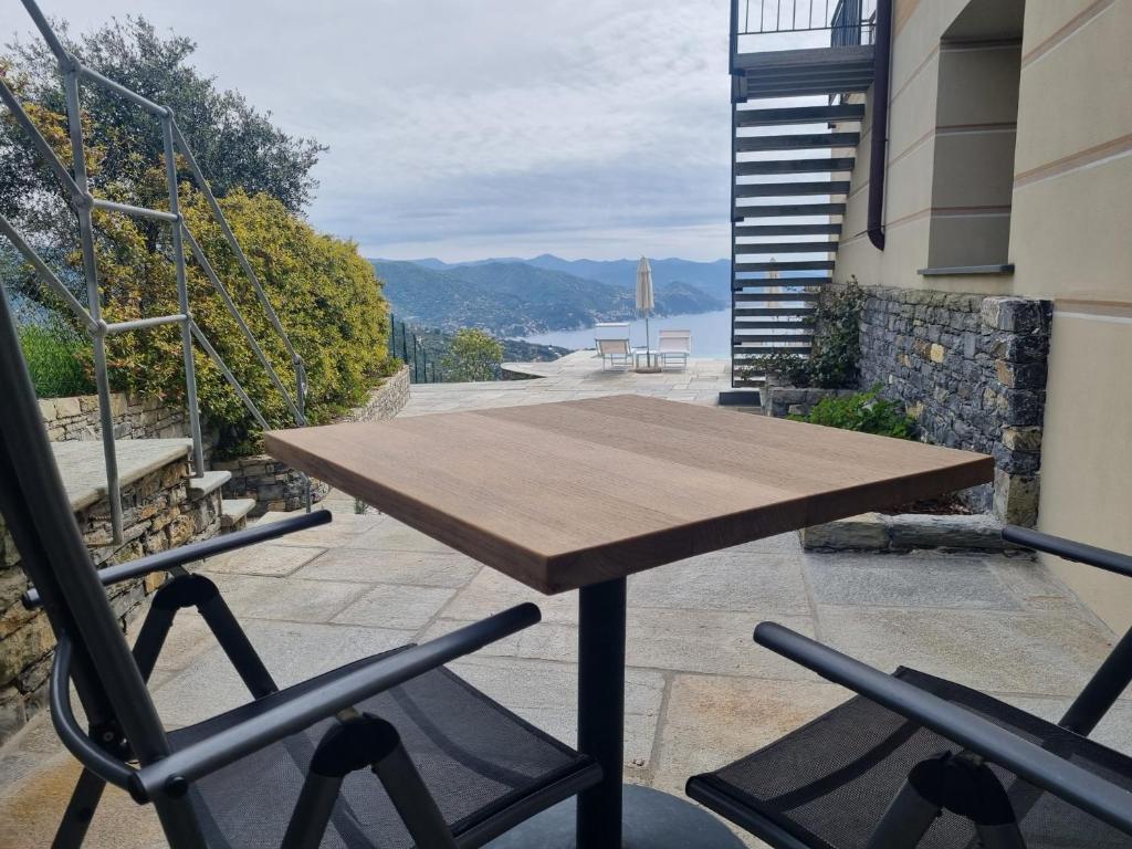 a wooden table and two chairs on a balcony at Il Leccio - Luxury Resort Portofino Monte in Santa Margherita Ligure