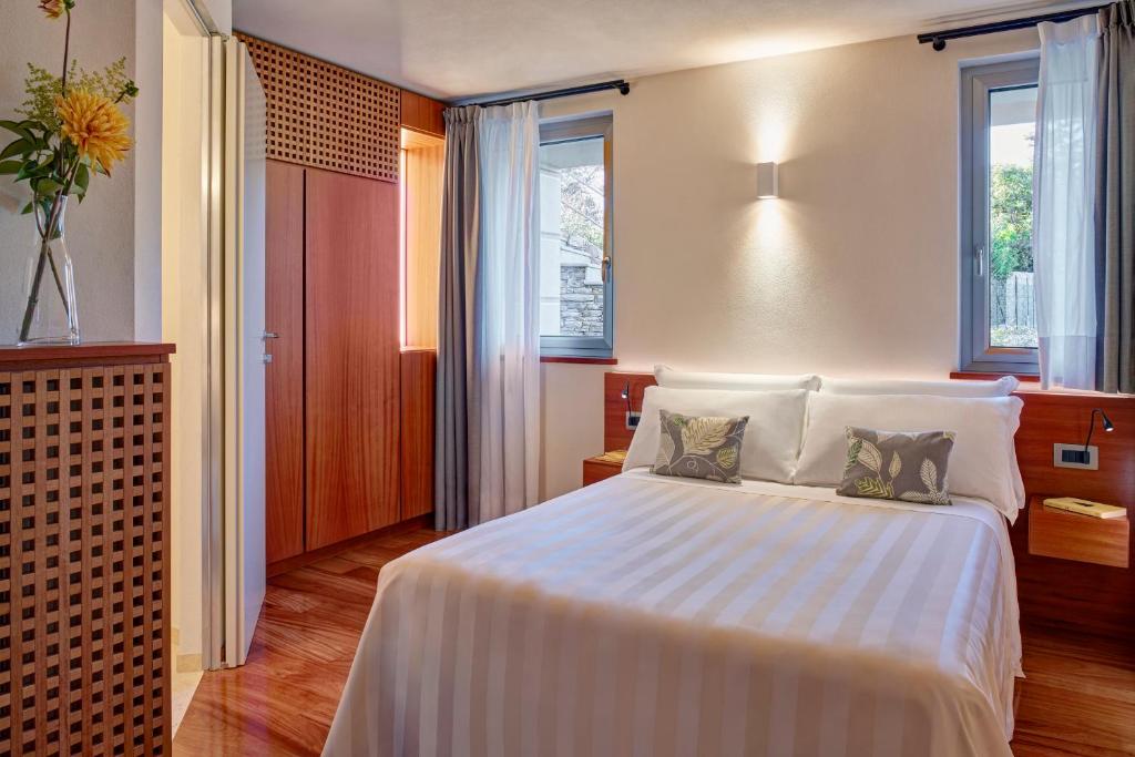 a bedroom with a large white bed with two pillows at Il Leccio - Luxury Resort Portofino Monte in Santa Margherita Ligure