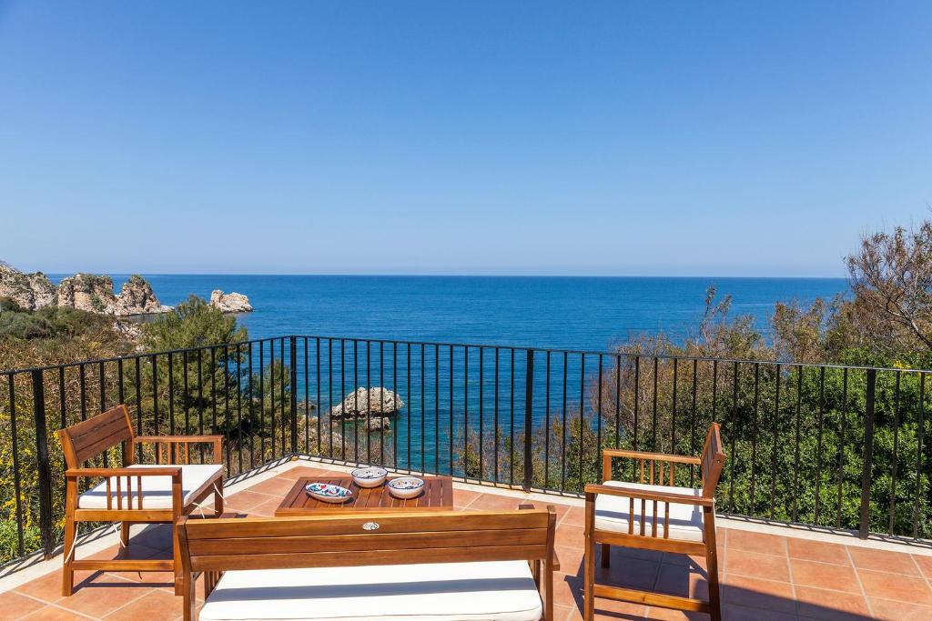 a patio with a table and chairs and the ocean at Villa La Fenice by Wonderful Italy in Castellammare del Golfo