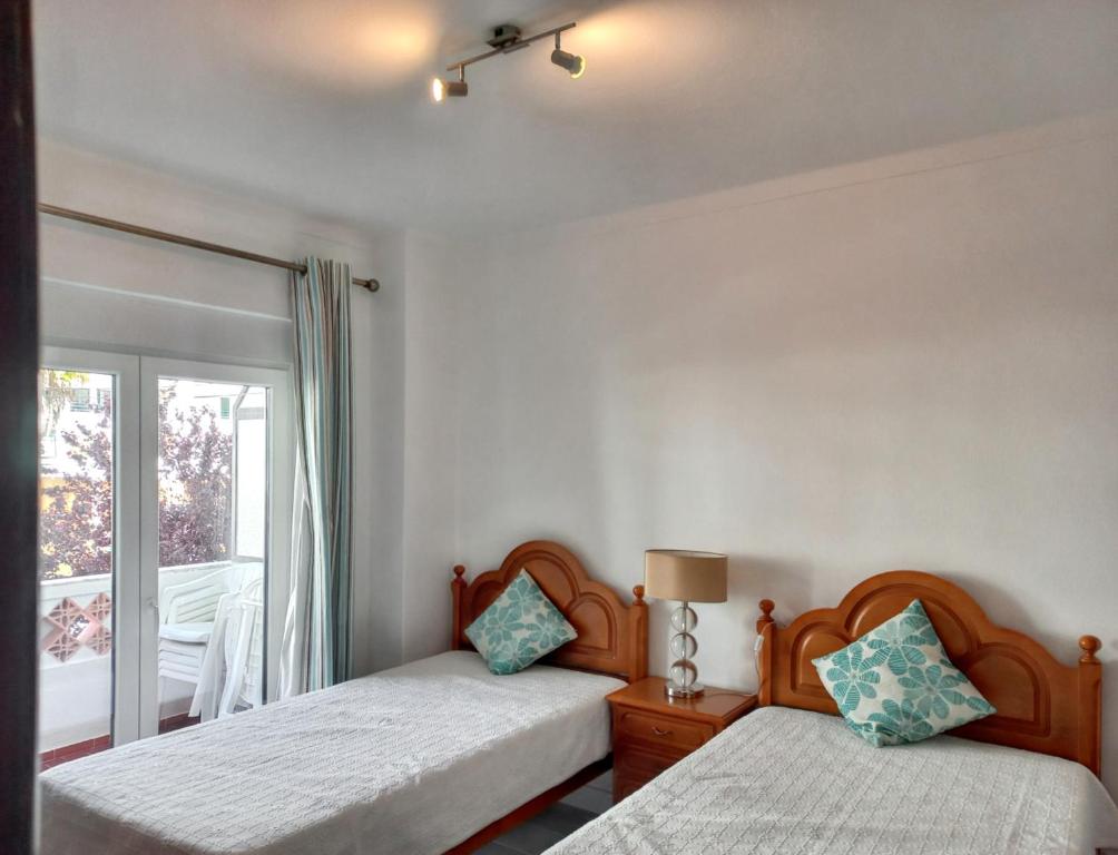 クアルテイラにあるOne bedroom apartement with city view furnished terrace and wifi at Quarteiraのベッドルーム1室(ベッド2台、窓付)