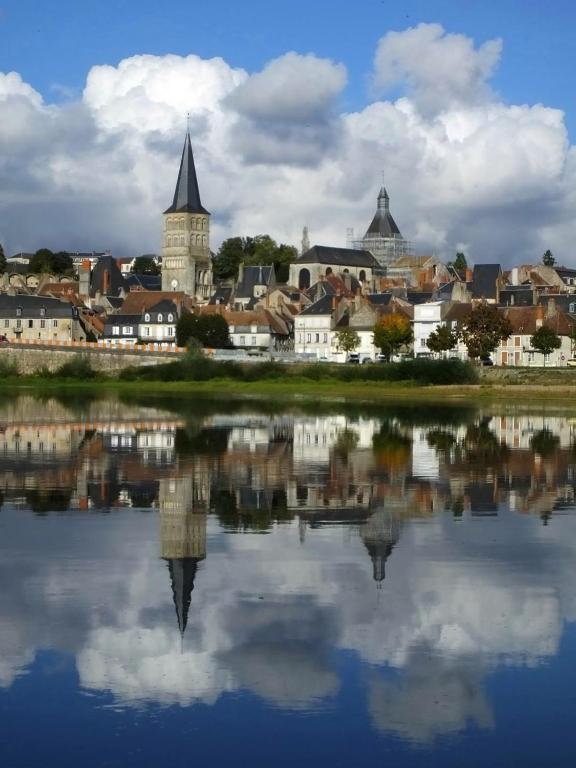 une ville avec sa réflexion dans l'eau dans l'établissement Le Logis des Ais, à La Charité-sur-Loire