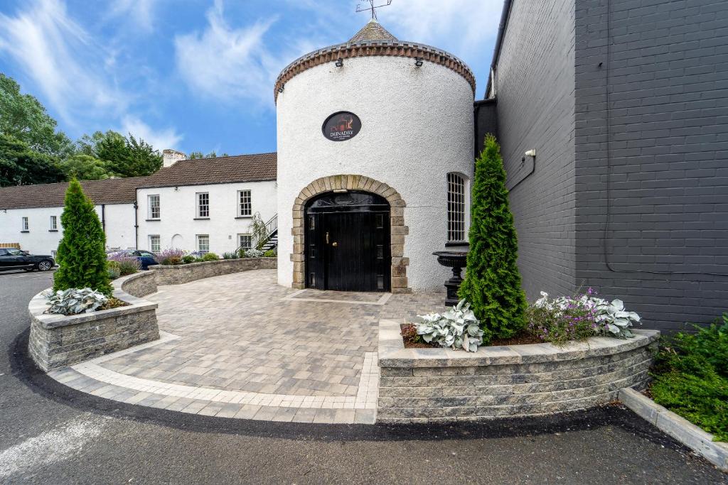a building with a black door and a brick driveway at Dunadry Hotel And Gardens in Antrim