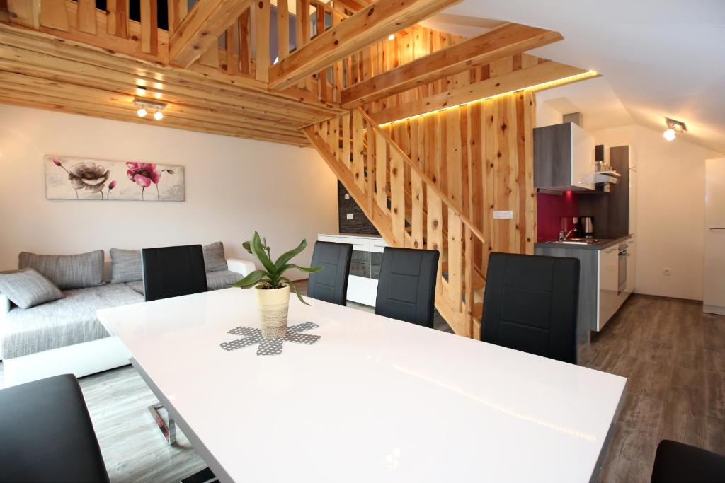 cocina y sala de estar con mesa blanca y sillas en Apartments Klemenčič en Bohinj