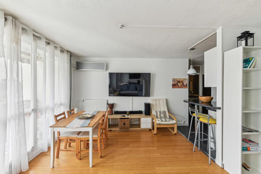 een keuken en eetkamer met een tafel en stoelen bij Chic and comfortable apart with balcony in Levallois-Perret