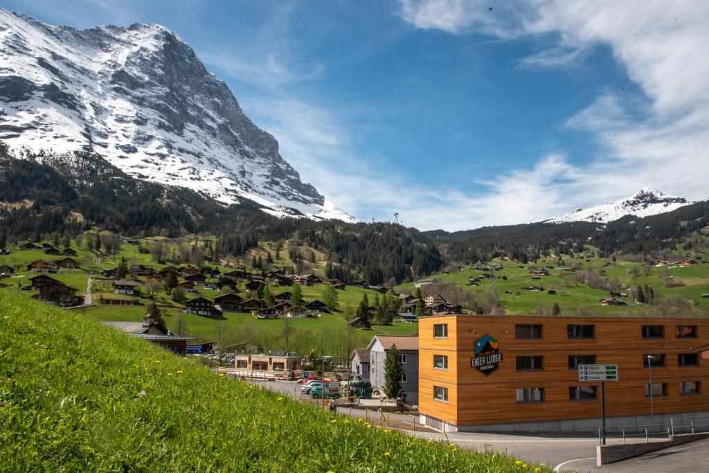 um edifício numa colina com montanhas ao fundo em Eiger Lodge Easy em Grindelwald