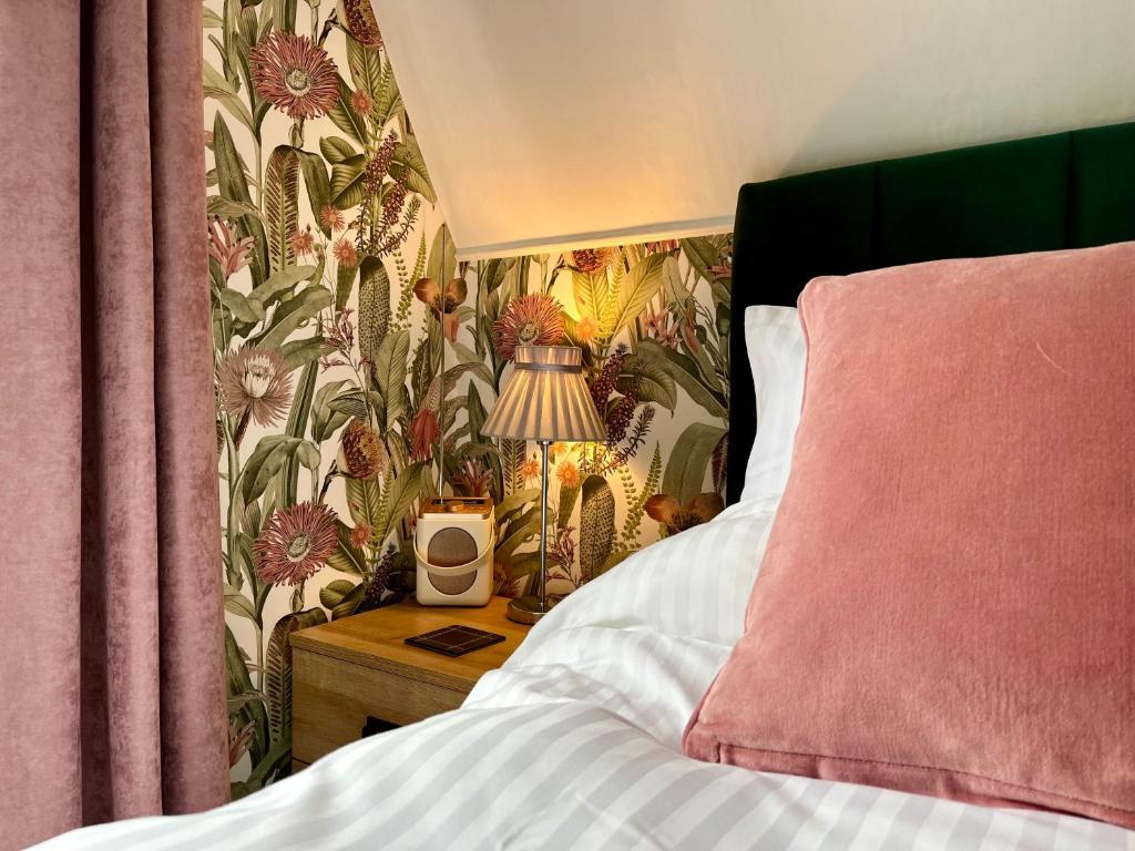 1 dormitorio con 1 cama y 1 mesa con lámpara en Southcliffe B&B, en Lynton