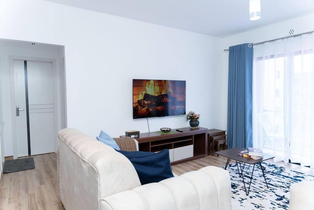 a white living room with a white couch and a table at BethelHomes in Tatu City