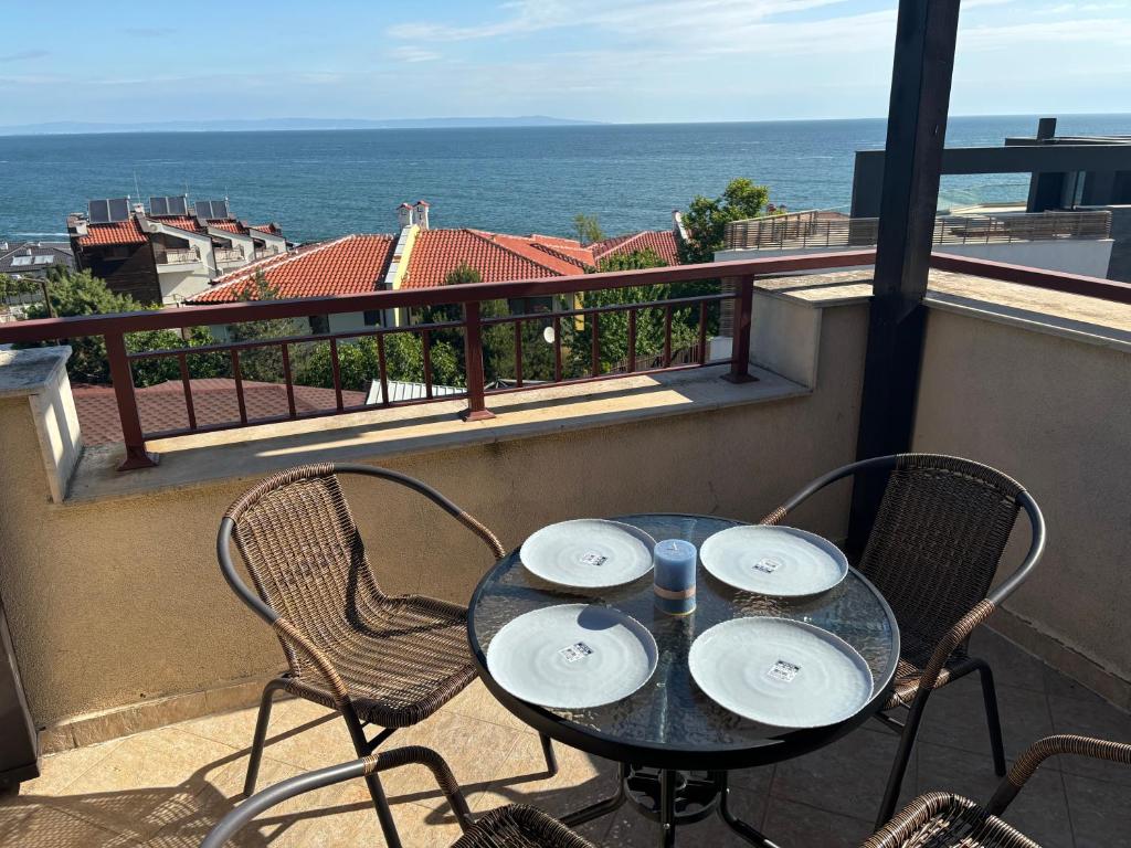 a table on a balcony with a view of the ocean at Sozopol Paradise view in Sozopol