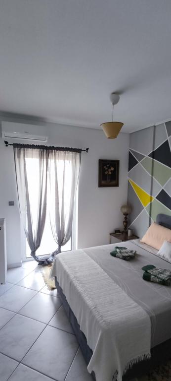 a bedroom with a large bed and two windows at Big,Smart & Comfort ! in Kalamata