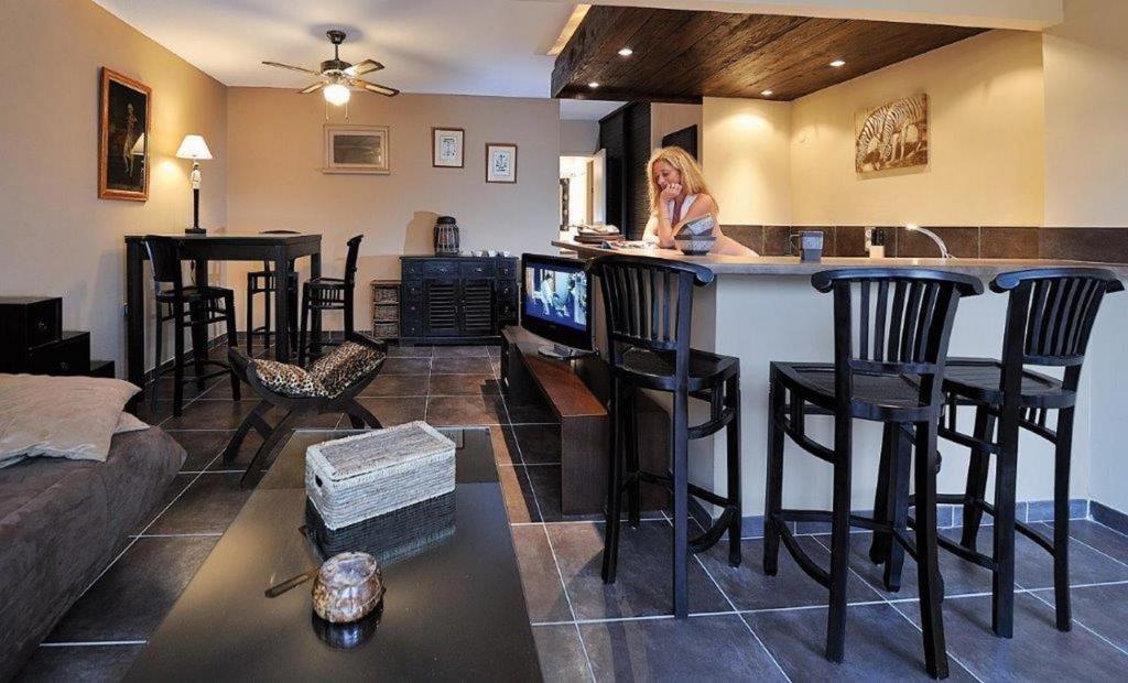 une femme assise dans un bar dans un salon dans l'établissement Villa COLONIALE - Villa Port Nature 116 - Luxe - 4 personnes, au Cap d'Agde