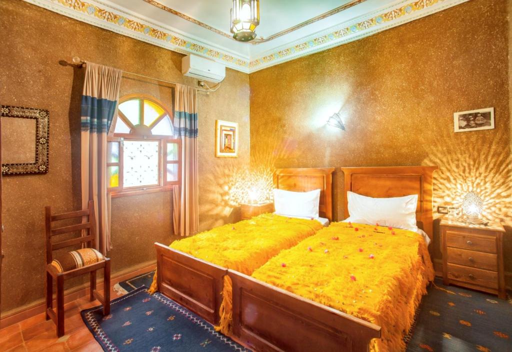 - une chambre avec un grand lit et une couverture jaune dans l'établissement 7 bedrooms house with shared pool terrace and wifi at Zagora, à Zagora
