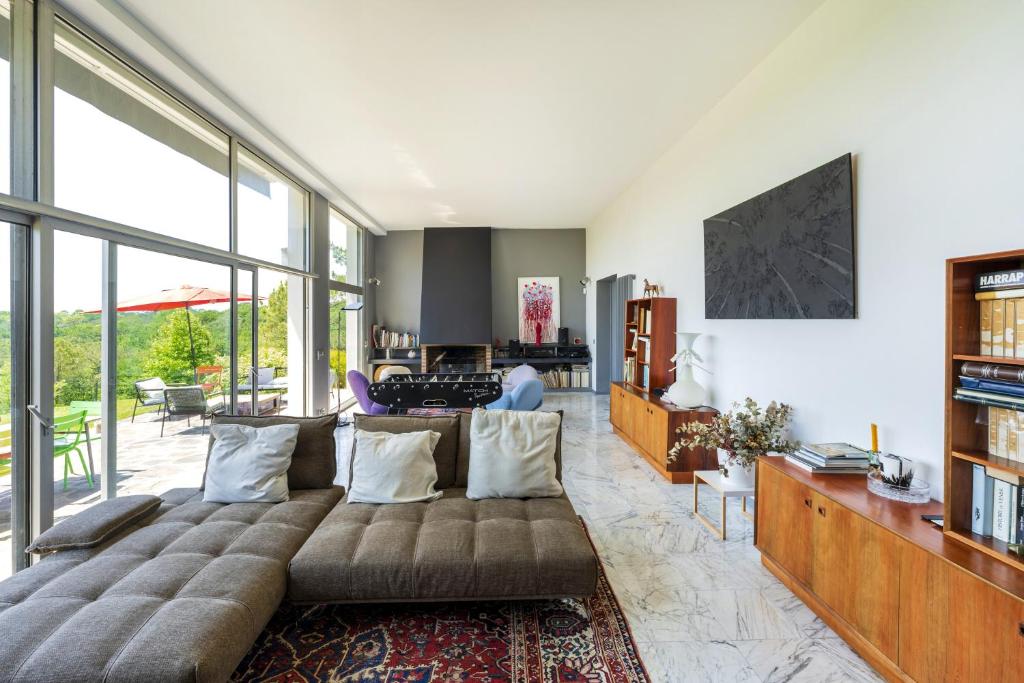 Saint-Martin-de-SeignanxにあるEspace, Luxe, Calme Et Natureのソファと大きな窓のあるリビングルーム