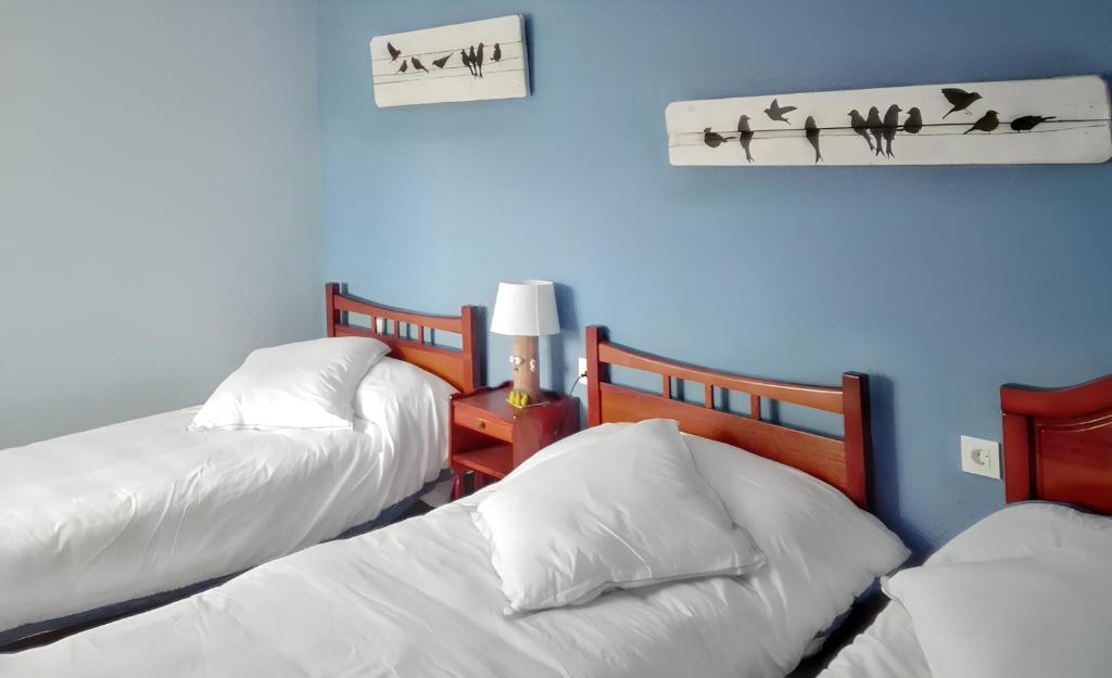 - une chambre avec 2 lits et un mur bleu dans l'établissement 3 bedrooms house with enclosed garden at Peral de Arlanza, à Peral de Arlanza