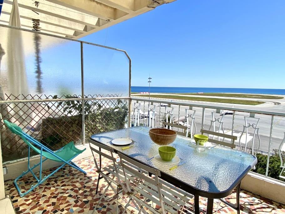 ein Tisch und Stühle auf einem Balkon mit Blick auf das Meer in der Unterkunft Large flat terrace Sea view, Promenade des Anglais in Nizza