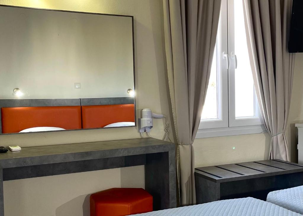 a mirror in a room with a bed and a window at Albatros Hotel in Karterados