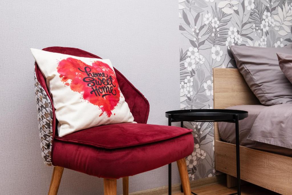 a red chair with a pillow on it next to a bed at Апартаменты Sweet Home in Kazan