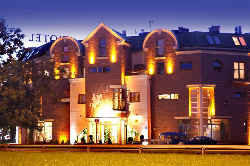 um grande edifício de tijolos com luzes amarelas em Grot Hotel em Malbork