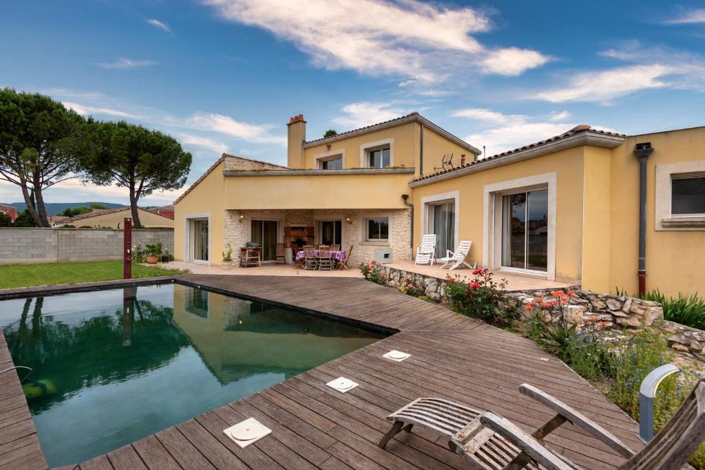 une cour arrière avec une piscine et une maison dans l'établissement Les Sylphides - Maison avec piscine, à Montélimar